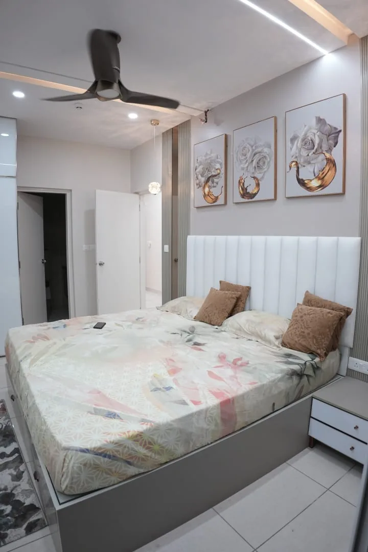 Bedroom with fluted upholstered headboard and framed art